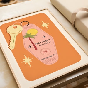 May include: A retro-style motel key tag with a pink background and a palm tree silhouette. The tag reads "Palm Canyon Motel & Resort" and "1989 Palm Springs, CA".