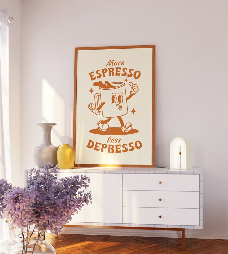 May include: A framed print with a cartoon illustration of a coffee cup with a face and arms. The text on the print reads "More Espresso Less Depresso".