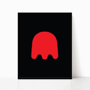 K&ouml;nnte beinhalten: Gerahmter Kunstdruck mit minimalistischem Design. Das Kunstwerk zeigt eine leuchtend rote, geister&auml;hnliche Form vor einem tiefschwarzen Hintergrund. Der Druck ist in einem schwarzen Rahmen eingefasst, was einen starken Kontrast erzeugt.