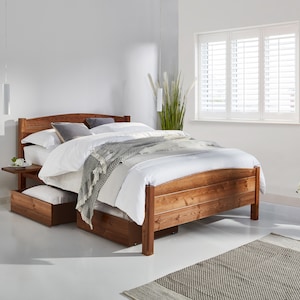 Peut inclure: Un cadre de lit en bois avec une tête de lit et un pied de lit blancs. Le lit est doté d'une couette blanche et d'une couverture grise. Il y a une petite table de chevet en bois à côté du lit.