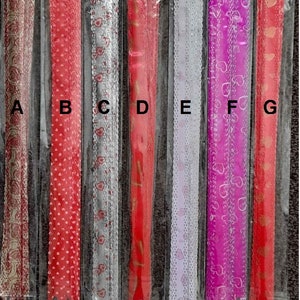 May include: Seven different ribbon trims with heart patterns. The ribbons are in various colours, including red, silver, white, pink, and gold. The ribbons are packaged in clear plastic.