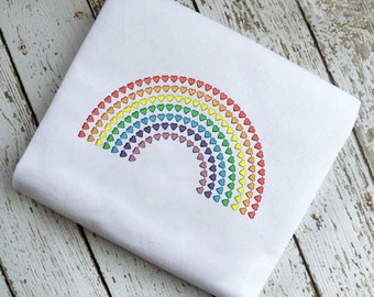 May include: A white fabric with a rainbow design made of small hearts. The rainbow is made of red, orange, yellow, green, blue, indigo, and violet hearts.