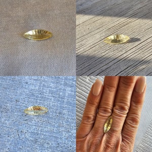 Może przedstawiać: Żółty kamień szlachetny o szlifie markizy z fasetkami. Kamień szlachetny jest pokazany na różnych powierzchniach, w tym na powierzchni tkaniny, powierzchni drewnianej i dłoni.