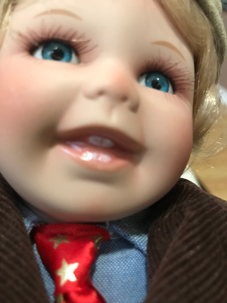 porcelain doll with blonde hair and blue eyes