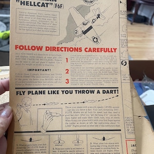May include: Vintage instruction sheet for a model American Grumman Hellcat (F6F) airplane. The tan paper features illustrations and text detailing assembly and flight instructions. Includes the text "Order your new planes now!"