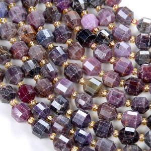 May include: A strand of faceted purple gemstone beads with gold spacers. The beads are a mix of light and dark purple hues.