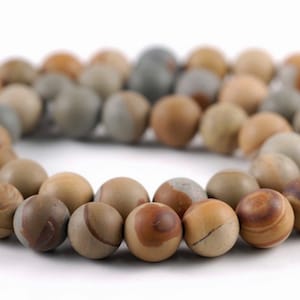 May include: A strand of brown, gray, and beige gemstone beads. The beads are round and have a natural, marbled pattern.