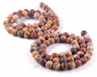 May include: A strand of brown, red, and white patterned round beads. The beads are strung on a clear thread and are arranged in a circle.