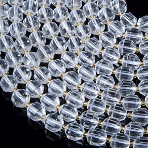 May include: A strand of clear faceted crystal beads with gold spacers. The beads are arranged in a staggered pattern.