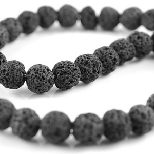 Peut inclure: Un collier de perles en lave noire. Les perles sont rondes et ont une surface rugueuse et texturée.