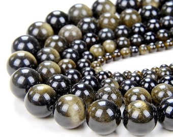 May include: A strand of round, black beads with gold flecks. The beads are of varying sizes and are arranged in a semi-circle.