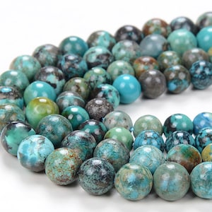 May include: A strand of turquoise beads with a mottled blue, green, and brown pattern. The beads are round and have a smooth, polished finish.