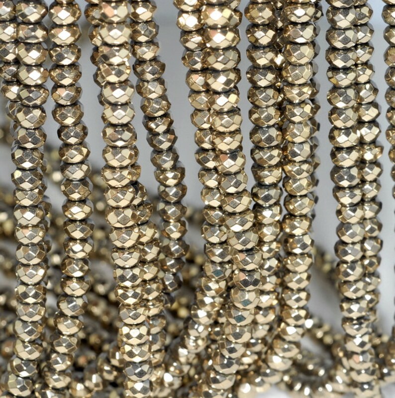 May include: Close-up of multiple strands of faceted, golden-colored beads. The beads are strung together, creating a textured and reflective surface. The beads are uniform in size and shape, and the overall effect is one of elegance and sophistication. Ideal for jewelry making.