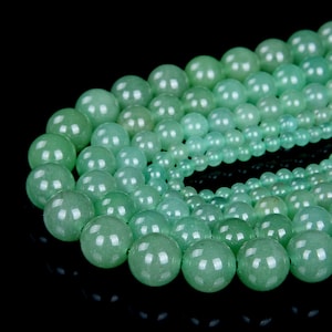 May include: A strand of green jade beads of varying sizes. The beads are round and smooth, with a polished finish.