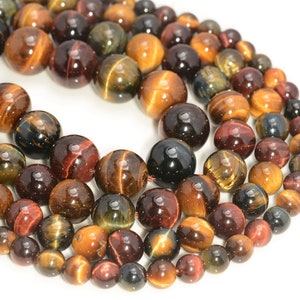 May include: A strand of round, multi-colored tiger's eye beads. The beads are a mix of brown, gold, red, and black with a shimmering, iridescent effect.