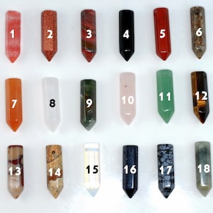 May include: Eighteen different colored gemstone points, each with a pointed tip, arranged in three rows of six. The points are numbered 1 through 18.