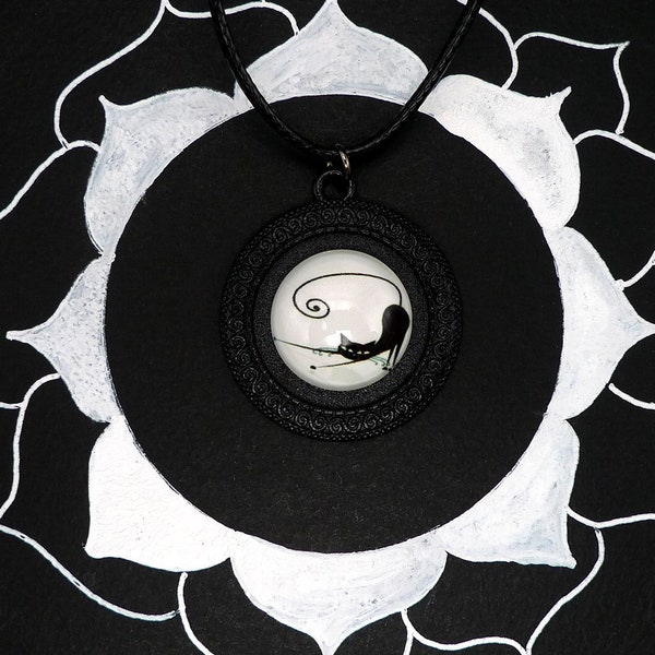 Collier pendentif chat qui s'étire en noir et blanc, support noir avec spirales gravées tout autour