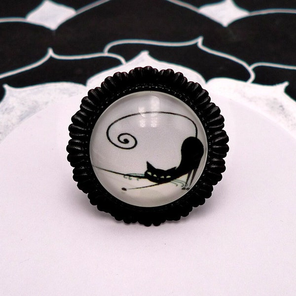 Bague réglable support noir motif végétal avec dessin de chat stylisé qui s'étire en noir et blanc