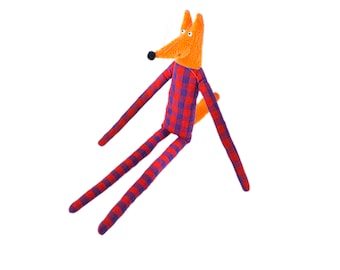 May include: A handmade plush fox toy with long limbs and a red and purple plaid pattern. The fox has a long, orange tail and a black nose.