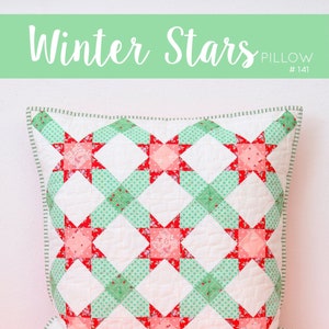 Könnte beinhalten: Ein Quiltmuster für ein Kissen mit einem Winterstern-Design in Rot, Weiß und Grün. Das Kissen ist 52 cm x 52 cm groß. Das Muster wurde von Nadra Ridgeway von ellisandhiggs.com entworfen.