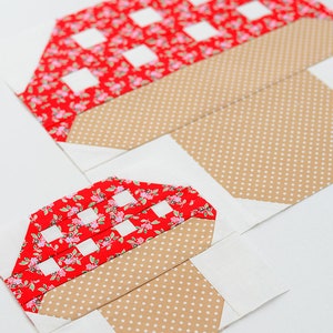 以下が含まれることがあります： 白地に、赤と白のギンガムチェックのキノコの形をした布のパッチが2つ、茶色の水玉模様の茎が付いています。パッチは白地に縫い付けられています。