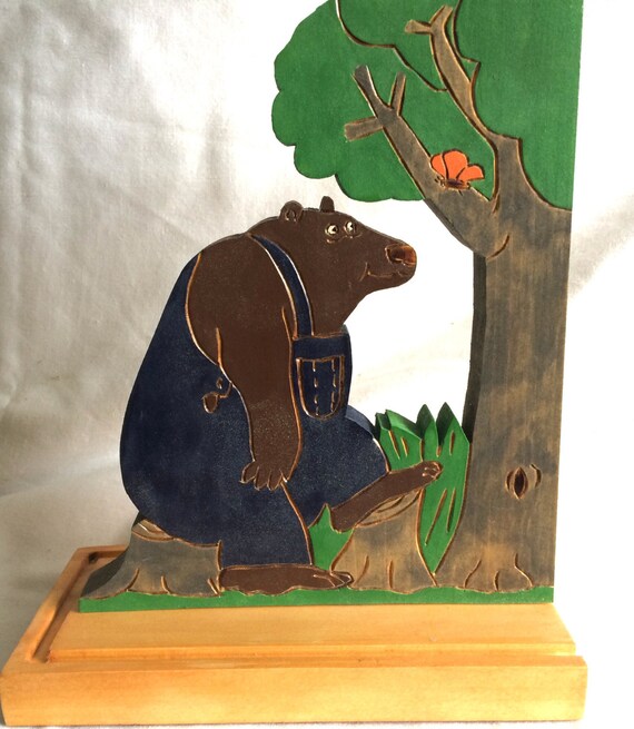 wooden bookend with a bear watching a butterfly