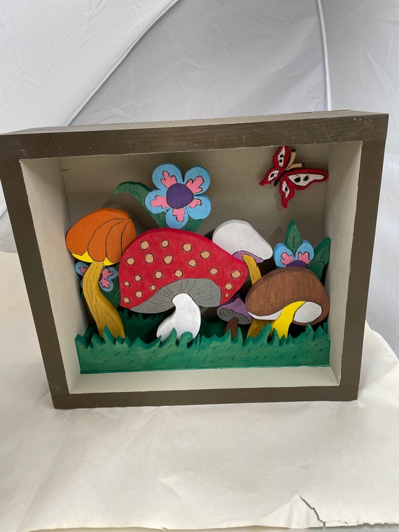 Wooden shadow box of colorful mushrooms