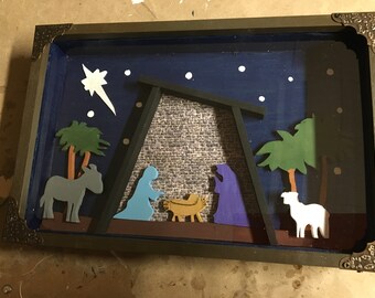 Wooden shadow box containing a colorful Manger Scene