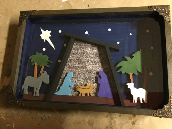 Wooden shadow box containing a colorful Manger Scene