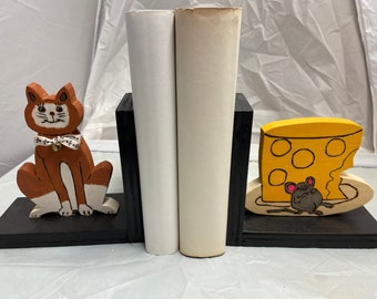 Wooden bookend that shows a brown cat and a cheese-stuffed mouse