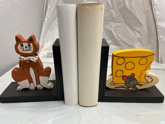 Wooden bookend that shows a brown cat and a cheese-stuffed mouse