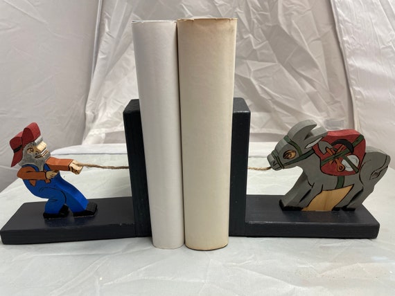 Wooden bookend of a miner and his mule