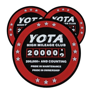 May include: Three red and black round patches with white text and stars. The center patch reads "YOTA HIGH MILEAGE CLUB 200002 200,000+ AND COUNTING PRIDE IN MAINTENANCE PRIDE IN OWNERSHIP".