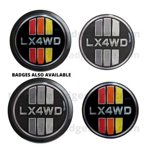 May include: Four circular black badges with the text "LX4WD" in silver. Two badges have red, orange, and yellow vertical stripes, while the other two have silver stripes. The text "BADGES ALSO AVAILABLE" is also visible.