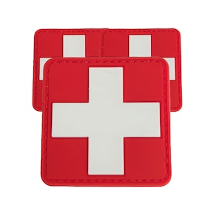 May include: Three red and white Swiss cross patches. The patches are made of a soft, flexible material and have a white stitched border.