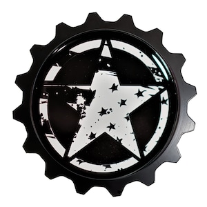 May include: Black and white star design on a black gear-shaped metal emblem. The star is distressed and has smaller stars inside it.