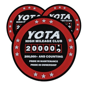 May include: Three red and black round stickers with white text and stars. The stickers say "YOTA HIGH MILEAGE CLUB 200,000+ AND COUNTING PRIDE IN MAINTENANCE PRIDE IN OWNERSHIP".