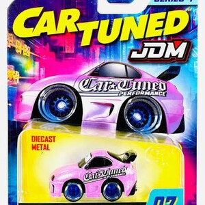 May include: A Car Tuned JDM Series 4 diecast metal 93 Toyota Supra toy car in pink with blue wheels, packaged on a colorful blister card featuring a large graphic of the vehicle, the text Car Tuned, JDM, and the number 07 in the corner.