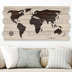 May include: A wooden world map wall art with a compass and the text "Life is a journey best traveled together Tom ♥ Kate".