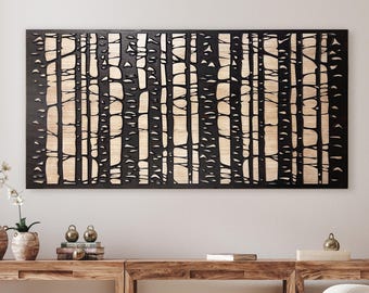 May include: Black metal wall art featuring a cutout design of a birch tree forest. The art is mounted on a wood panel and has a natural wood grain finish.