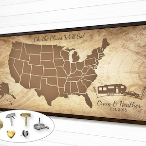 May include: A vintage-style map of the United States with a camper and a car driving on a road. The map is framed in a brown wood frame. The text "Oh, the Places We'll Go!" is at the top of the map. The text "Craig & Heather Est. 2015" is at the bottom of the map.