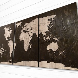 May include: A three-piece wooden world map wall art set with a compass design. The map is laser-cut and features a dark brown wood finish with a light brown wood inlay.