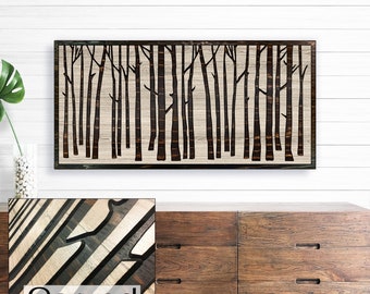 May include: A wood wall art piece with a carved design of a forest. The art is framed in a black frame and has a light wood background. The word "Carved" is printed below the art piece.