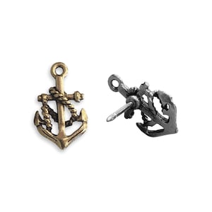 May include: Two anchor-shaped metal charms, one gold and one silver. The gold charm has a rope design and the silver charm has a pin on the back.