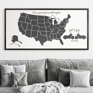May include: Framed wall art featuring a map of the United States in dark gray against a white background. The text "Life is a journey best traveled together" is above the map. Below the map are two motorcycle silhouettes with the names "Jeff & Julie" and the year "Est. 2011".