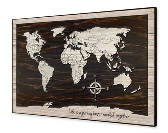 May include: A wooden world map with a compass in the center. The map is surrounded by a dark brown frame and has a white background. The text "Life is a journey best traveled together" is written below the map.