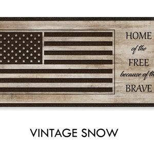 May include: A wooden sign with a distressed wood background and a black American flag design. The text "HOME of the FREE because of the BRAVE" is printed in black on the right side of the sign.