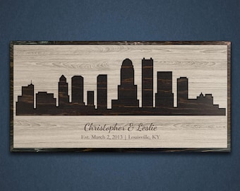 May include: A wooden sign with a black silhouette of the Louisville, Kentucky skyline. The sign is personalized with the names "Christopher & Leslie" and the date "Est. March 2, 2013".