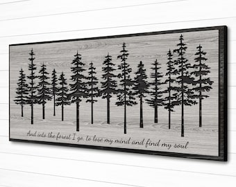 May include: A framed wooden wall art piece featuring a forest silhouette design. The artwork displays a row of black pine trees against a gray wood-grain background. The text "And into the forest I go, to lose my mind and find my soul" is at the bottom.
