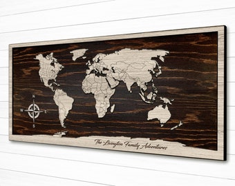 May include: A wooden world map with a compass and the text "The Livingston Family Adventures". The map is dark brown with a light brown frame and a white world map design.